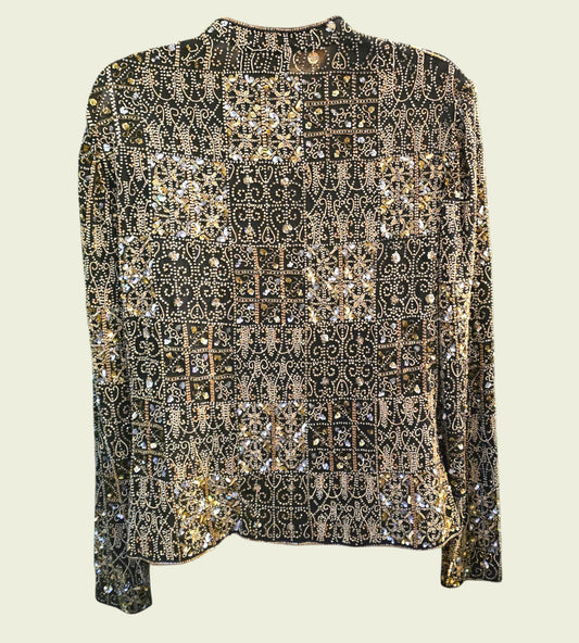 Elegant black and gold patterned blouse on a light beige background