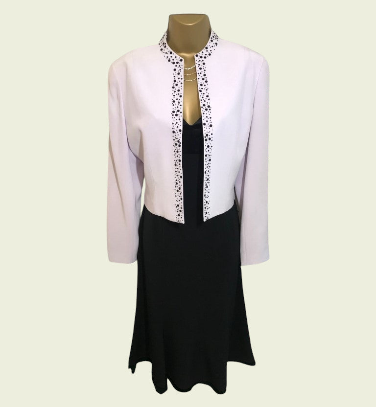 Mannequin wearing a lilac jacket and a black dress on a light beige background
