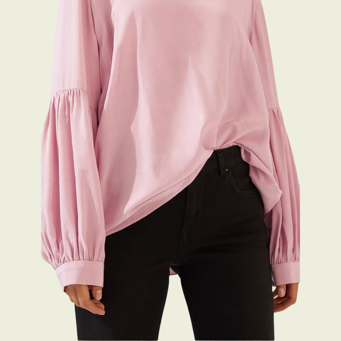 Pink blouse with balloon sleeves worn by a person on a beige background