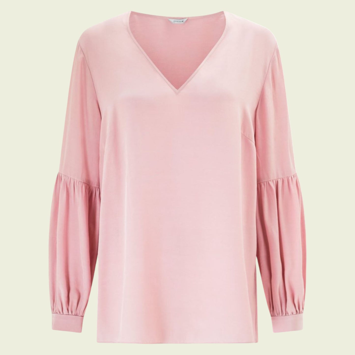 Pink long-sleeve top on a light green background