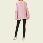 Pink sweater worn by a person on a plain background