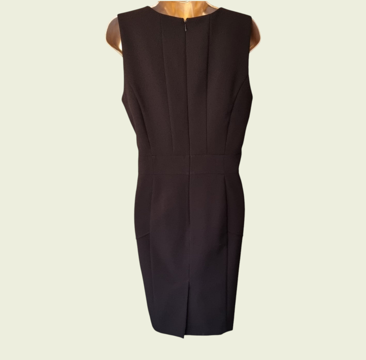 Black sleeveless dress on a beige background