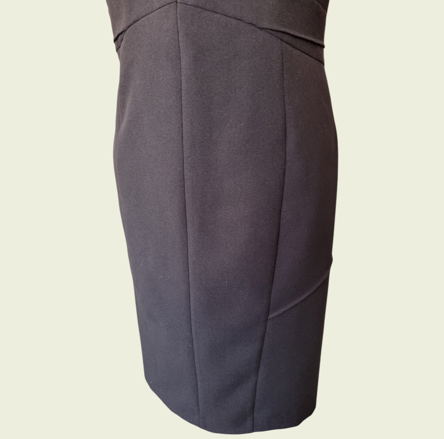 Black pencil dress on a beige background