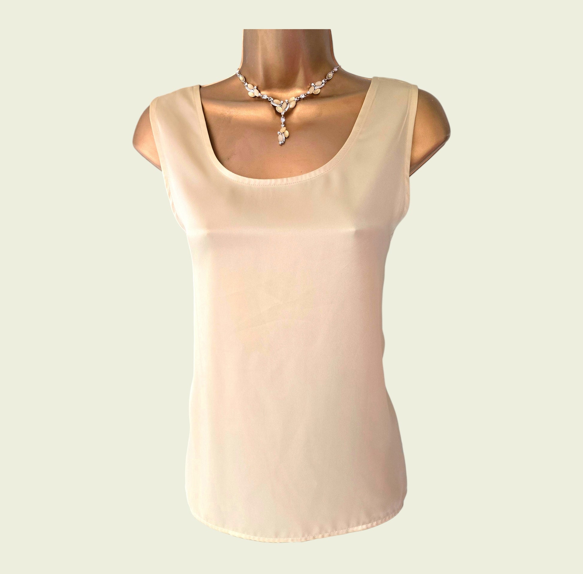 Yellow sleeveless top on a mannequin with a plain background