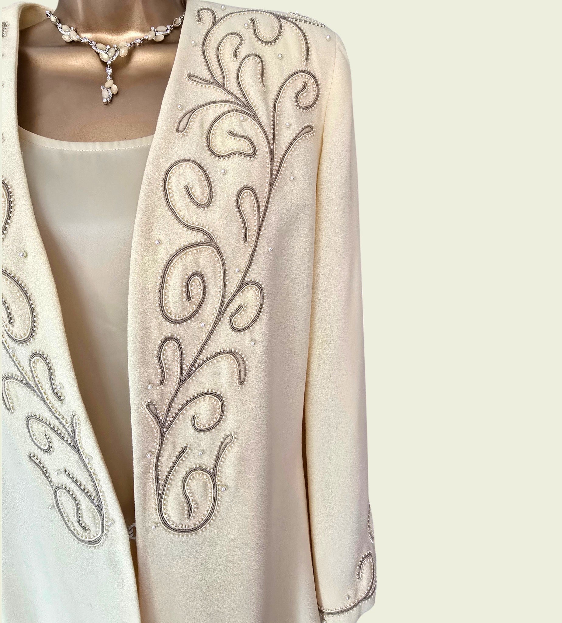 Yellow colored embroidered jacket on a mannequin with a white background