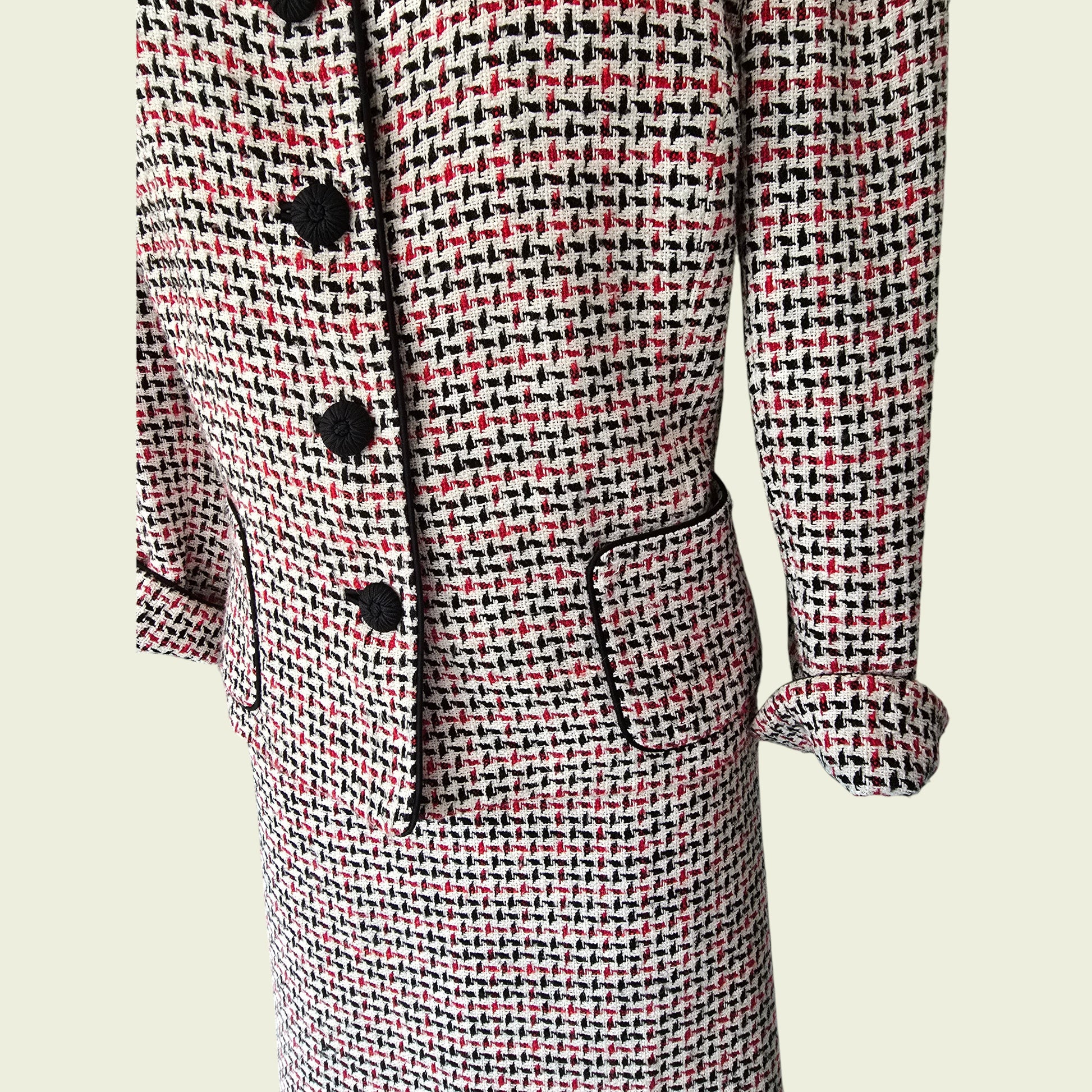 Houndstooth patterned suit with black buttons on a beige background