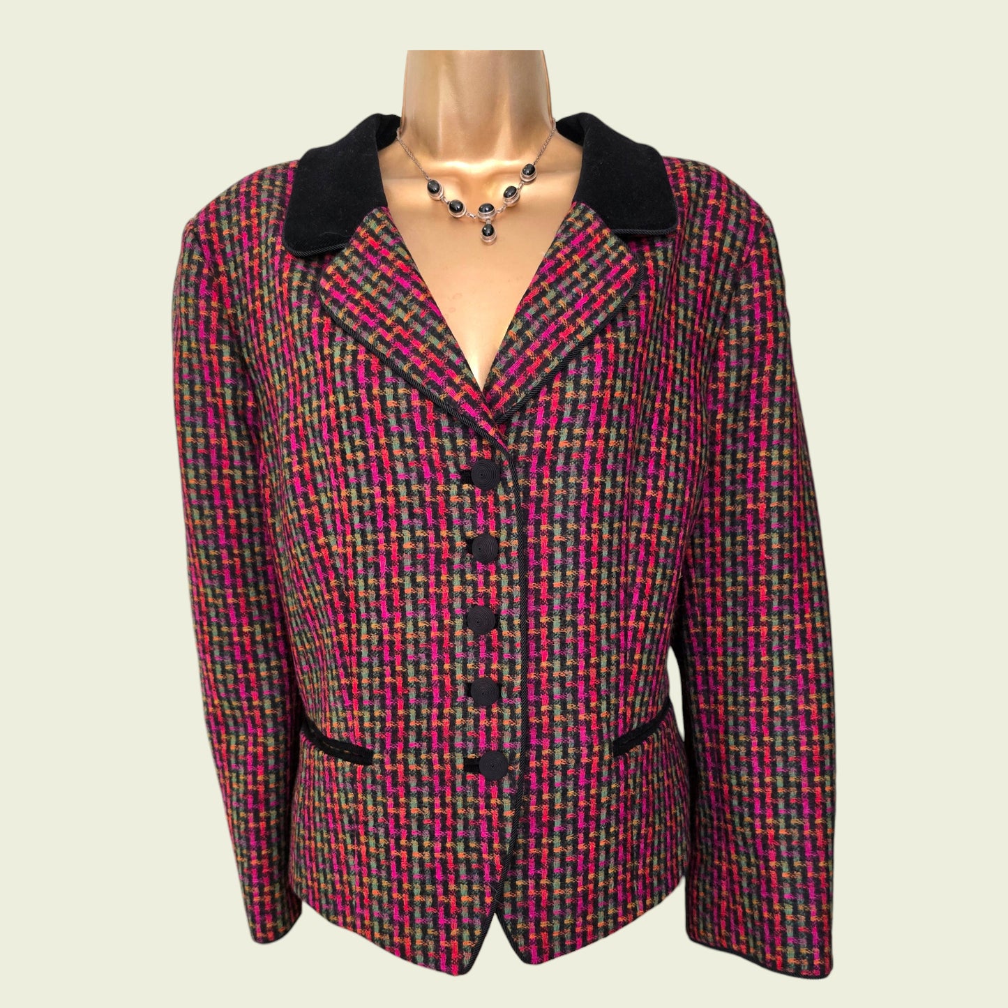 Multicolored patterned blazer on a mannequin against a plain background
