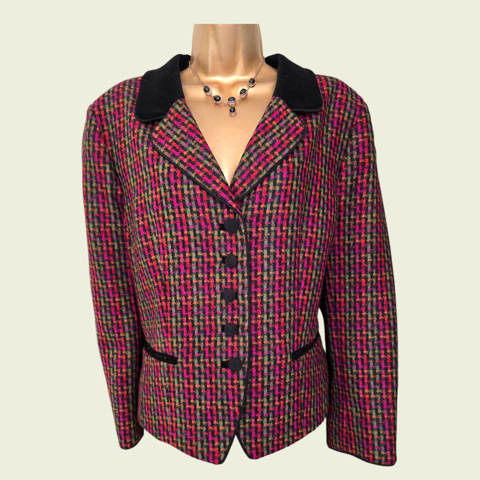 Multicolored patterned blazer on a mannequin against a plain background