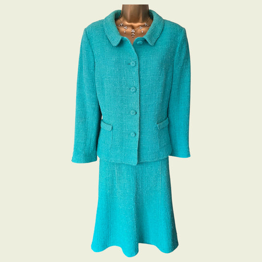 Turquoise skirt suit on a mannequin against a beige background