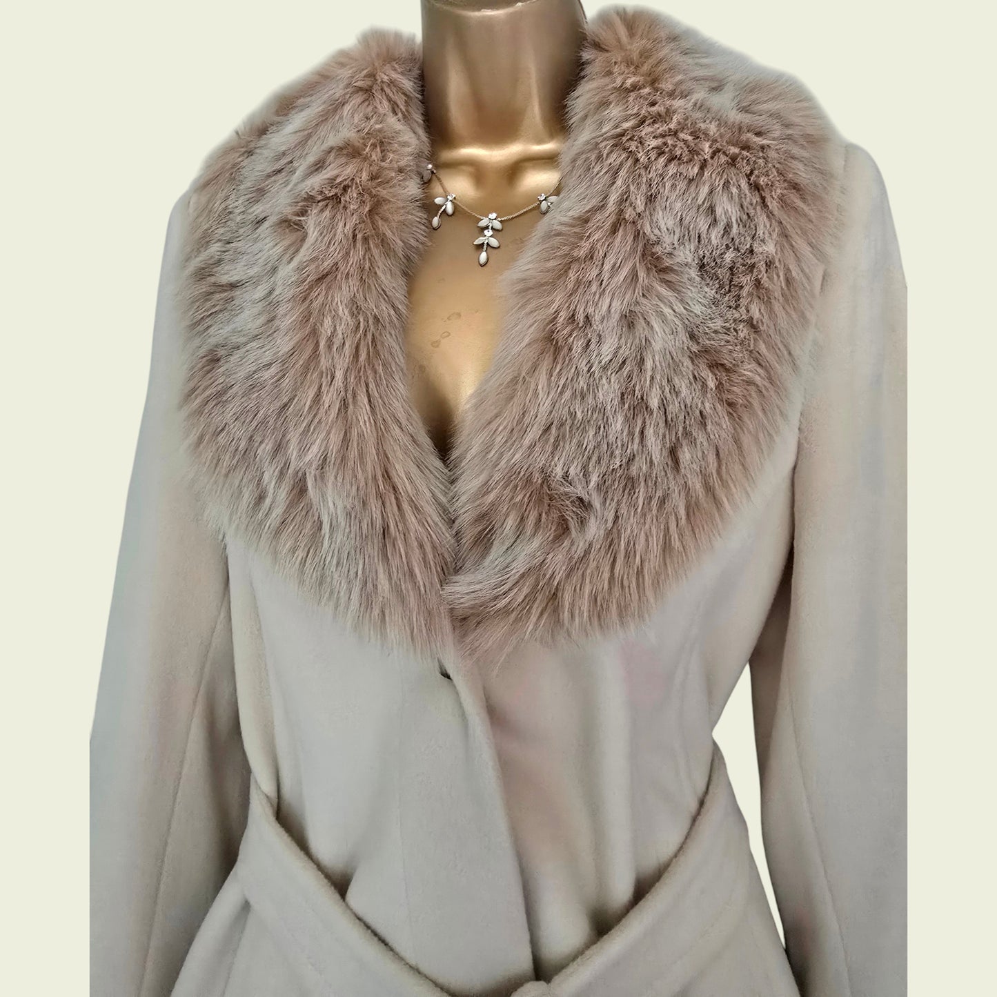 Mannequin wearing a beige coat with a fur collar on a light beige background