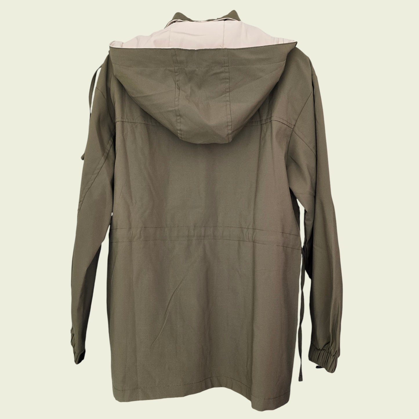 Green hooded jacket on a beige background