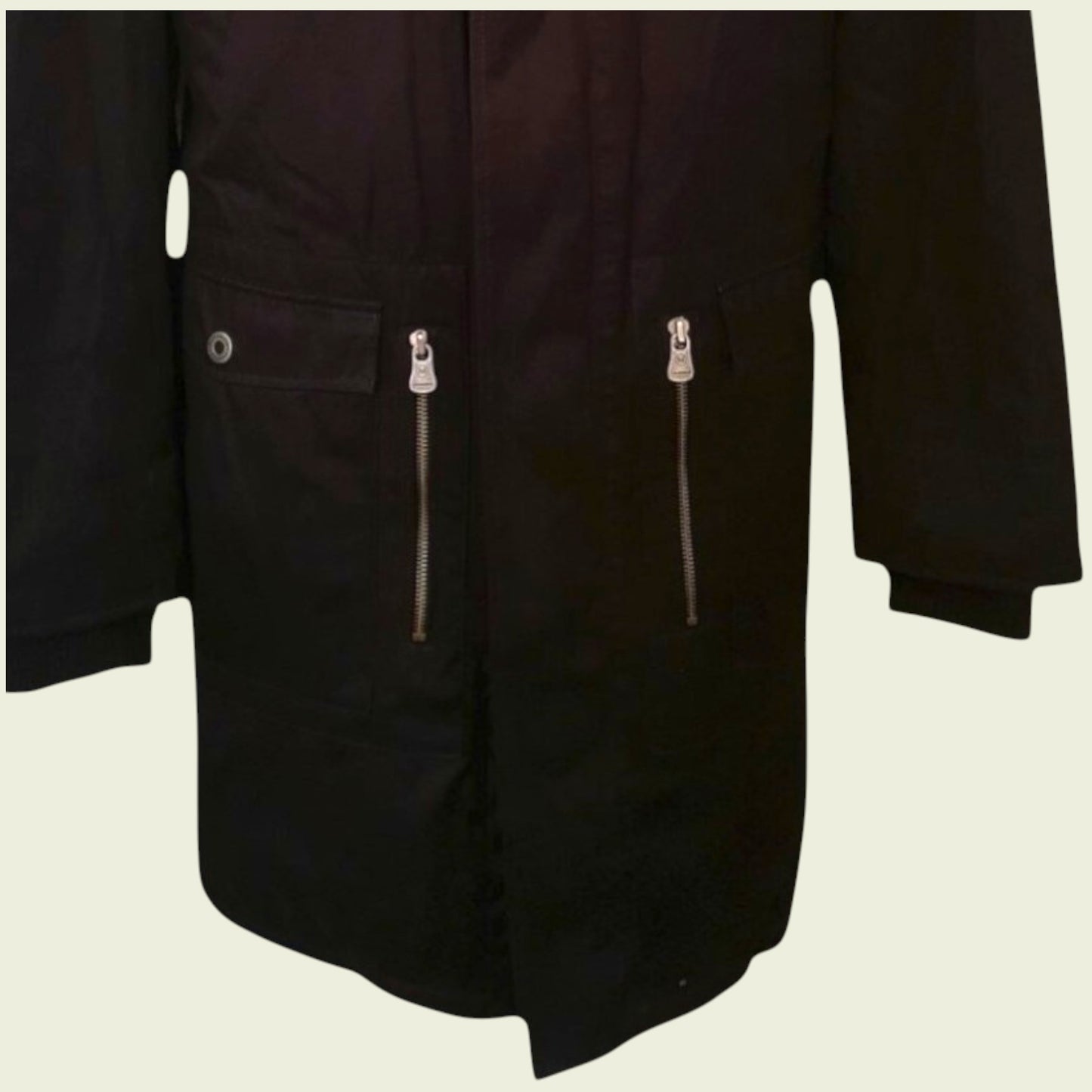 Black coat with zippers on a beige background