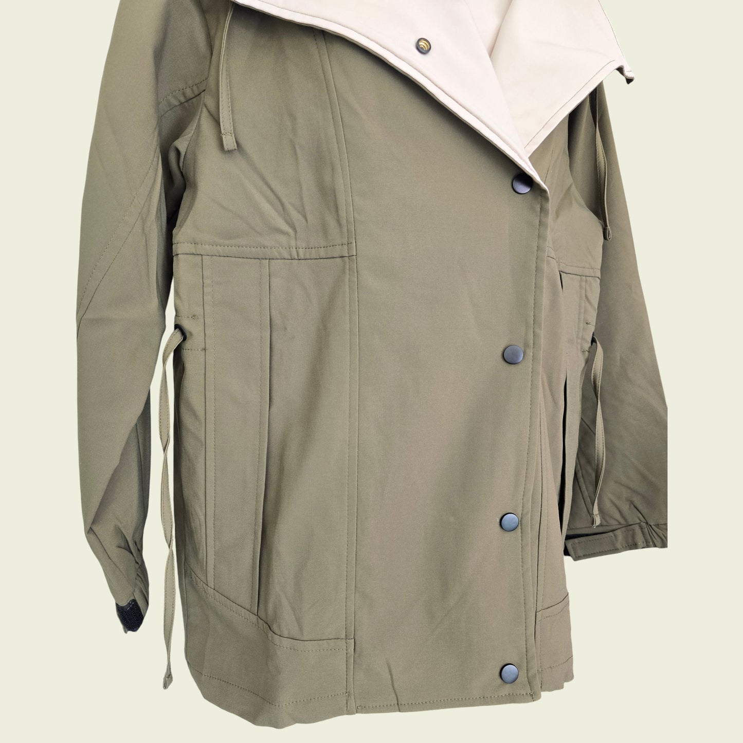 Khaki jacket with button details on a beige background