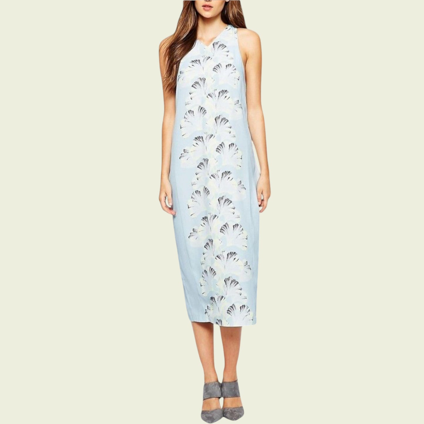 Woman wearing a light blue sleeveless dress with a floral pattern on a beige background