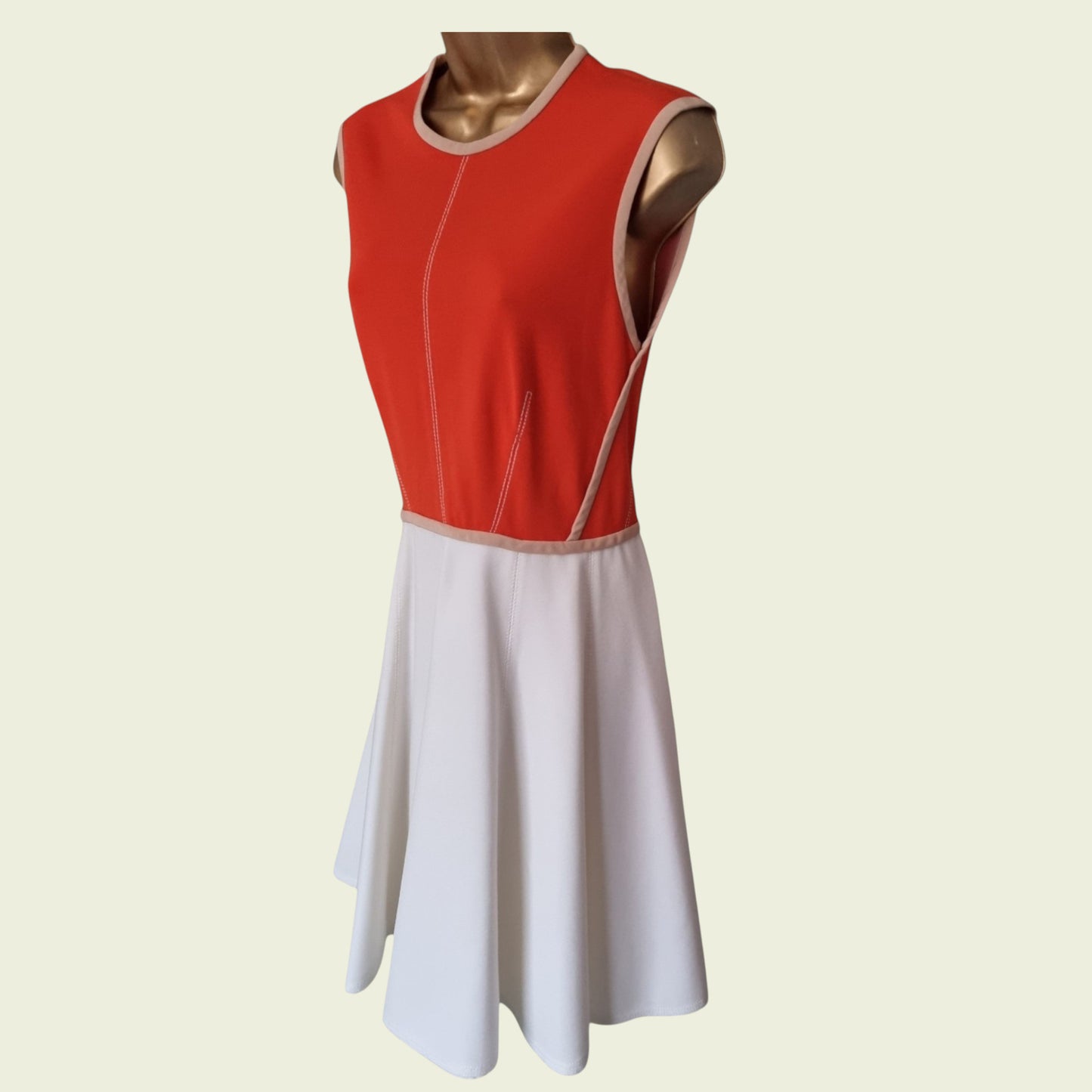 Red and white dress on a mannequin against a beige background