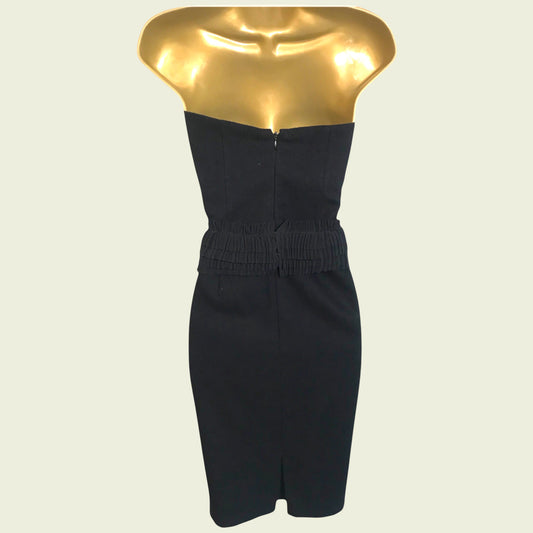 Black strapless dress on a gold mannequin against a beige background