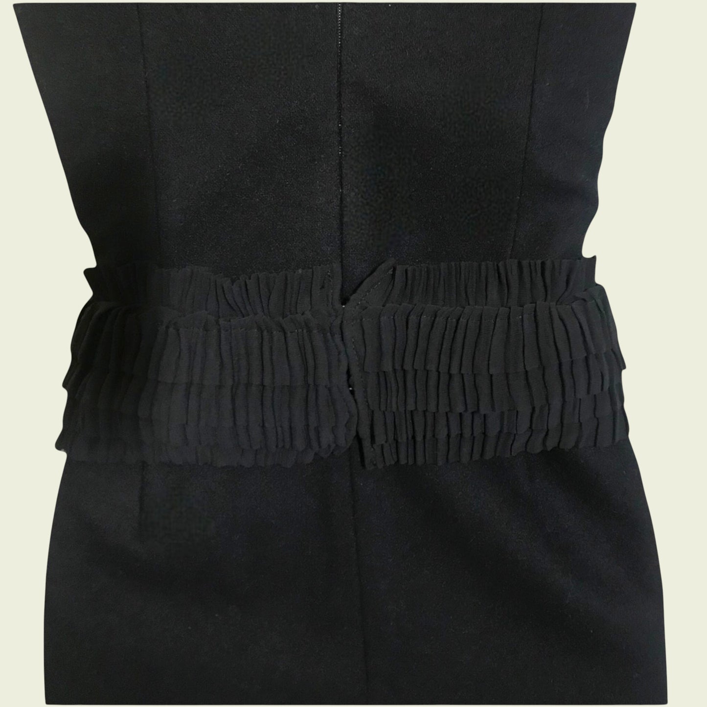 Black dress with a textured belt on a beige background