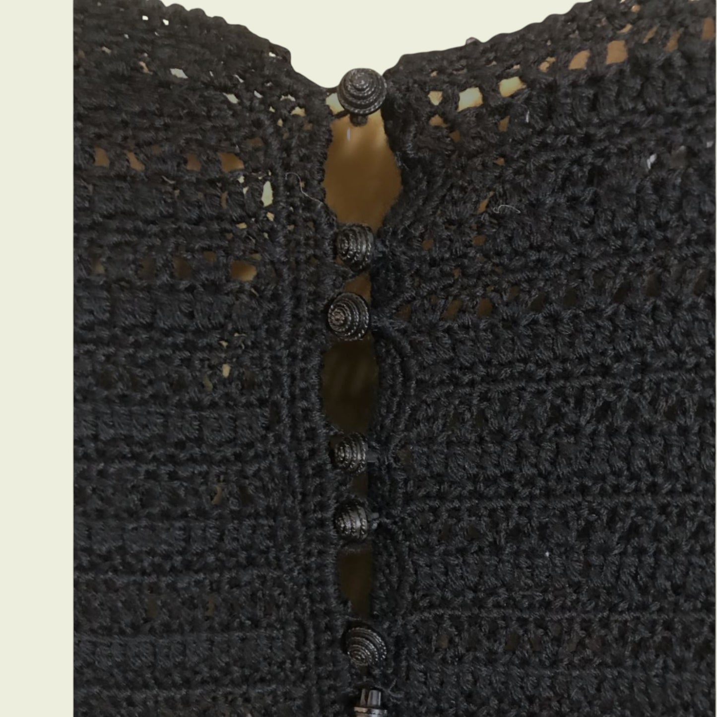 Close-up of a black textured fabric with button details