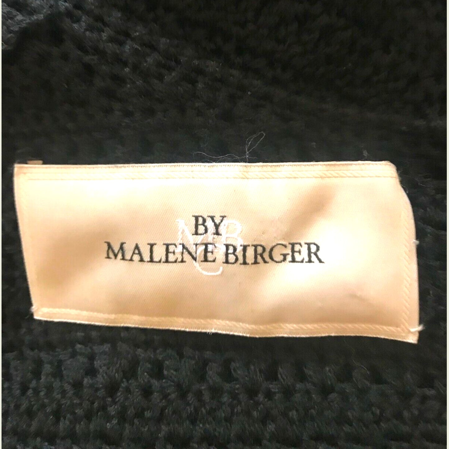 Label with 'By Malene Birger' text on a textured black background