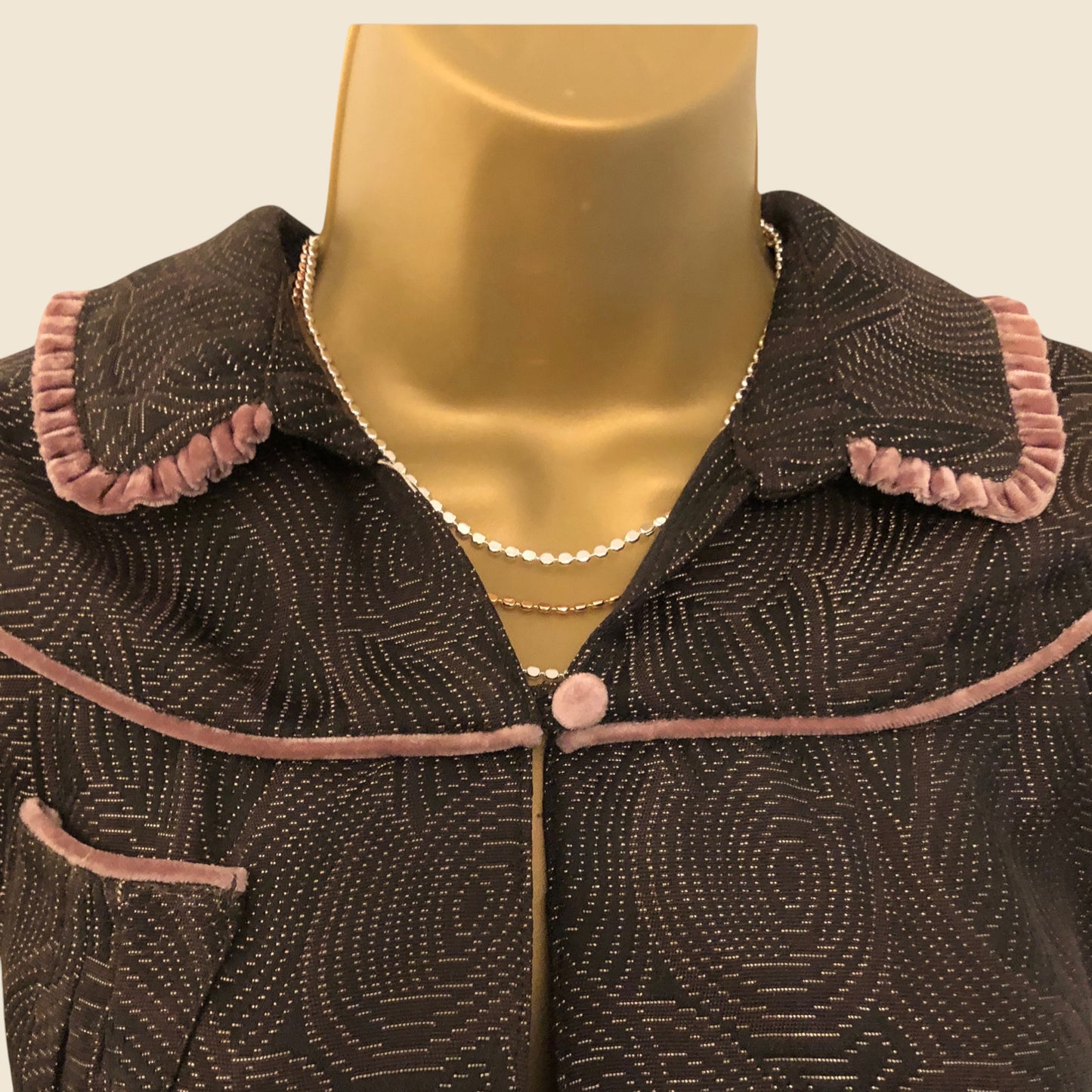 Brown textured collar with pink trim on a mannequin against a beige background