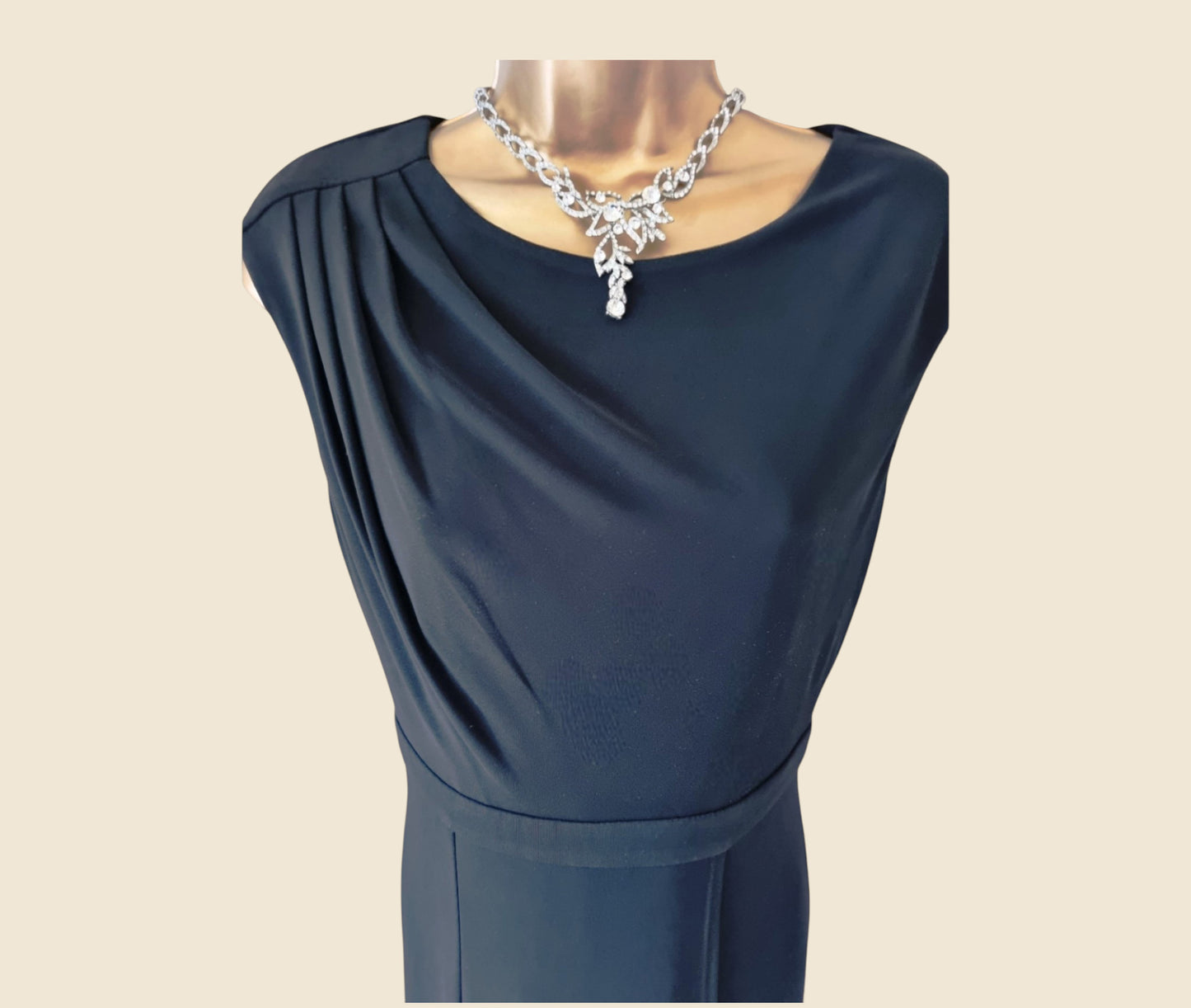 Black dress on a mannequin with a beige background