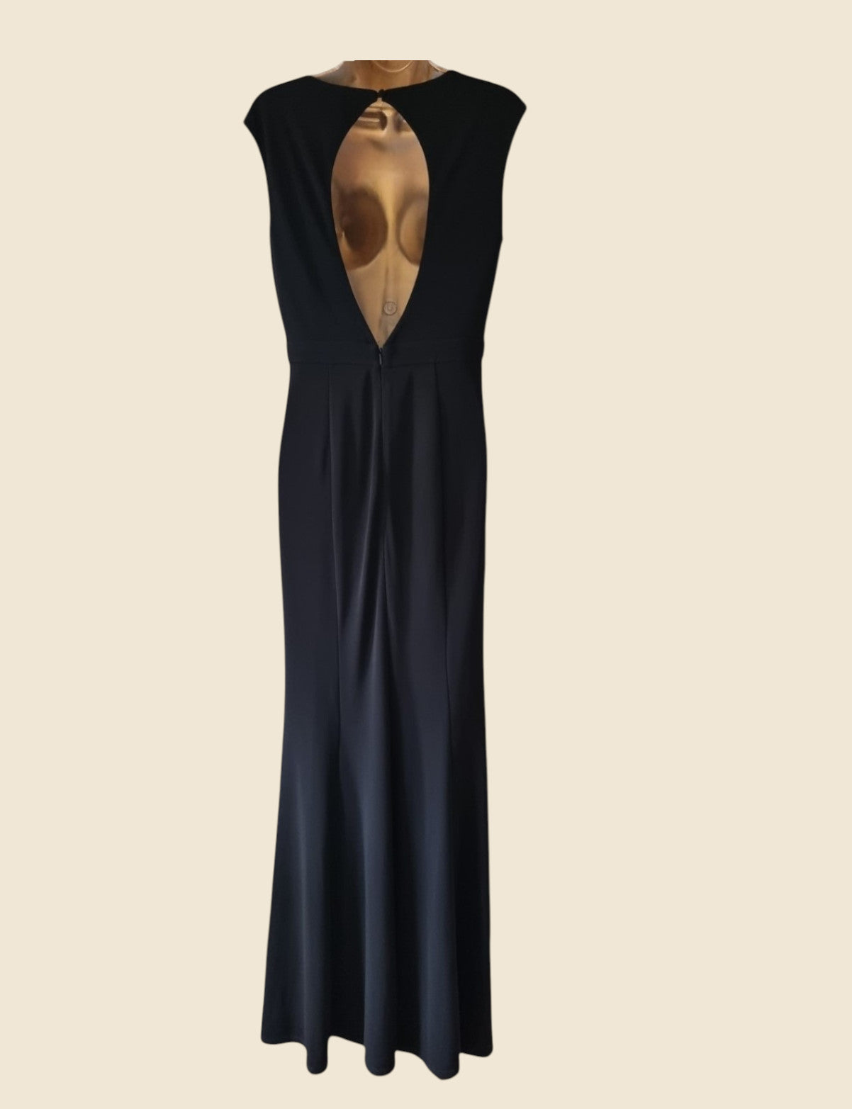 Black sleeveless dress with a deep neckline on a beige background