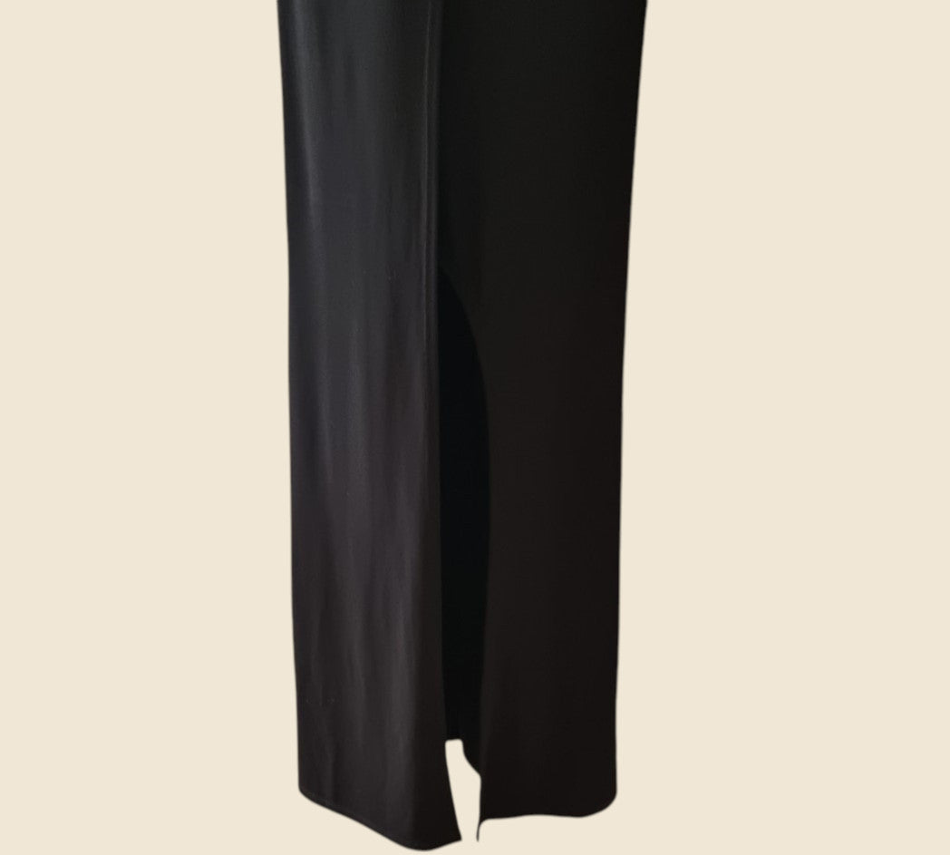Black dress showing front split on a beige background