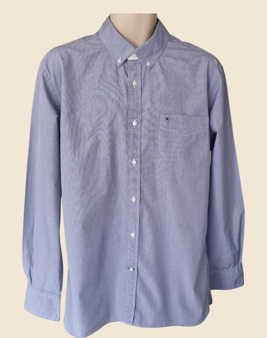 Blue button-up shirt on a mannequin against a beige background