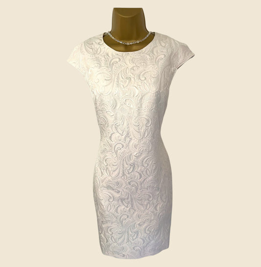 White lace dress on a mannequin against a beige background