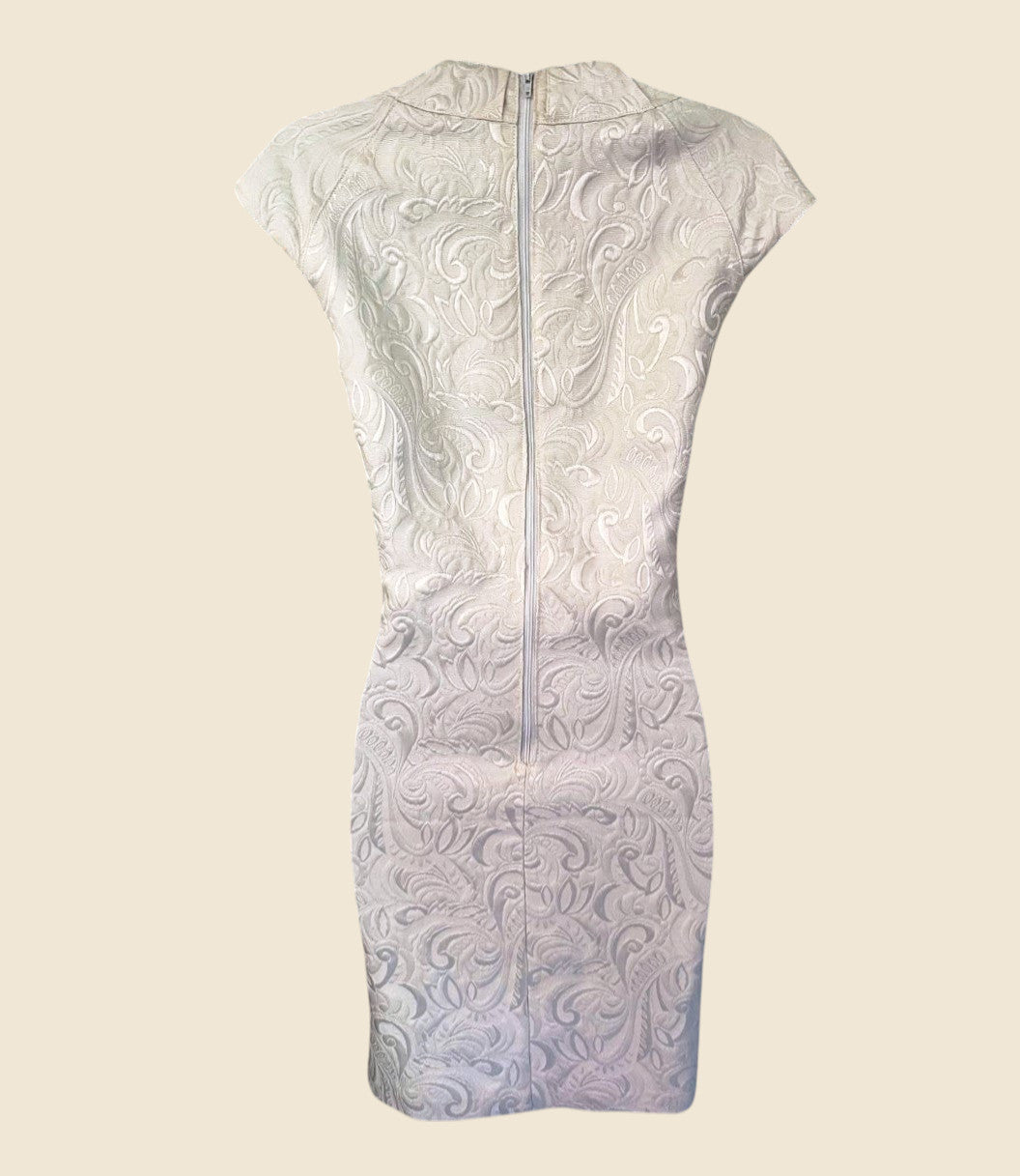 White lace dress with a subtle pattern on a beige background