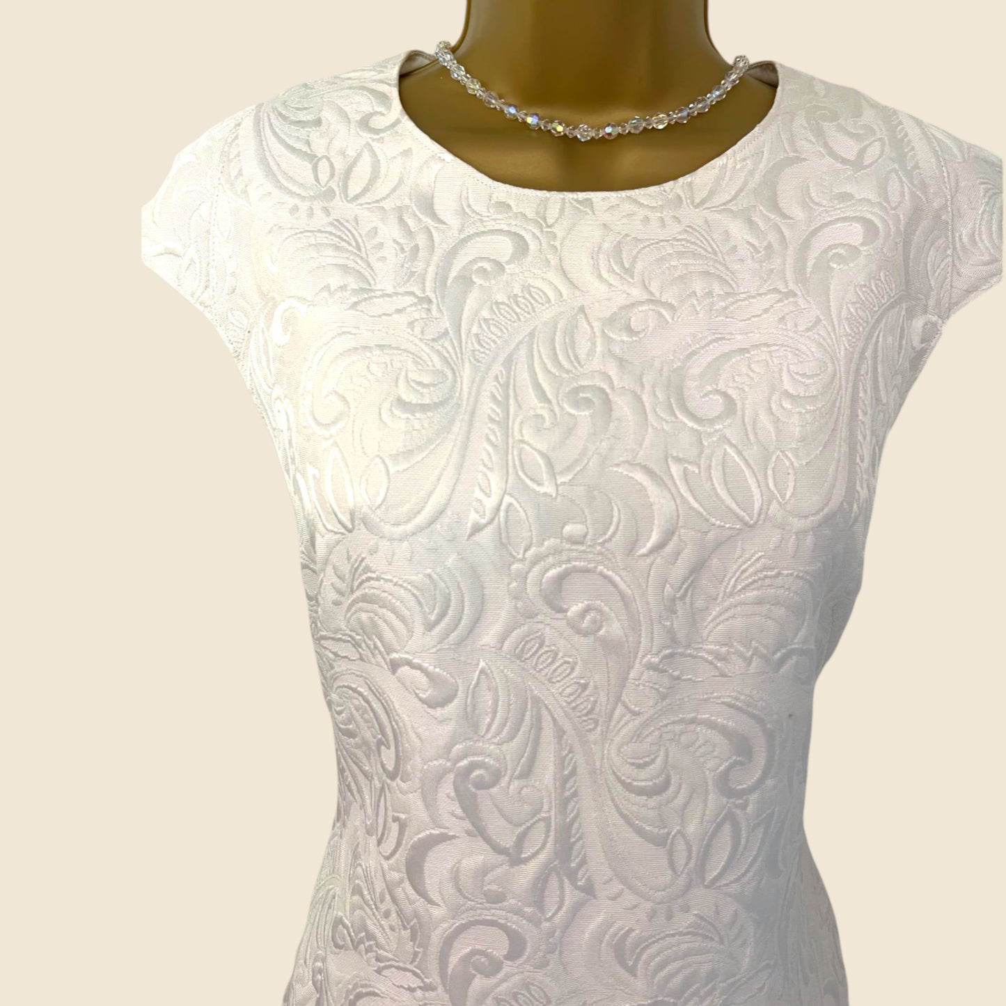 White lace top on a mannequin with a beige background