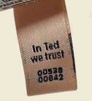 Textile label with 'In Ted we trust' printed on it.