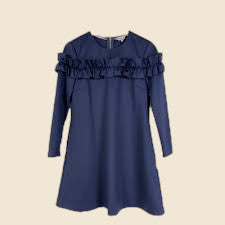 Blue dress with ruffled details on a beige background