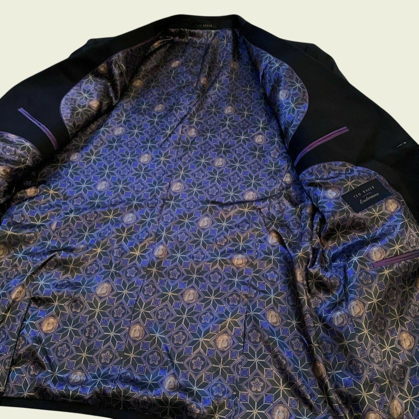Black garment with blue geometric pattern on a beige background