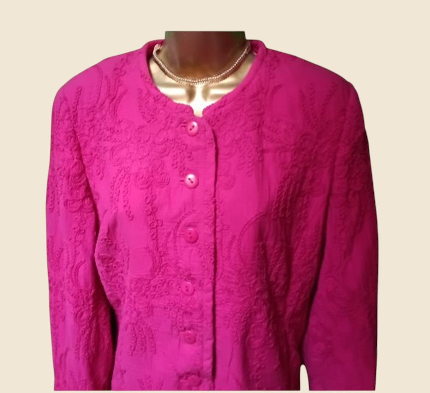 Pink textured jacket on a mannequin against a beige background