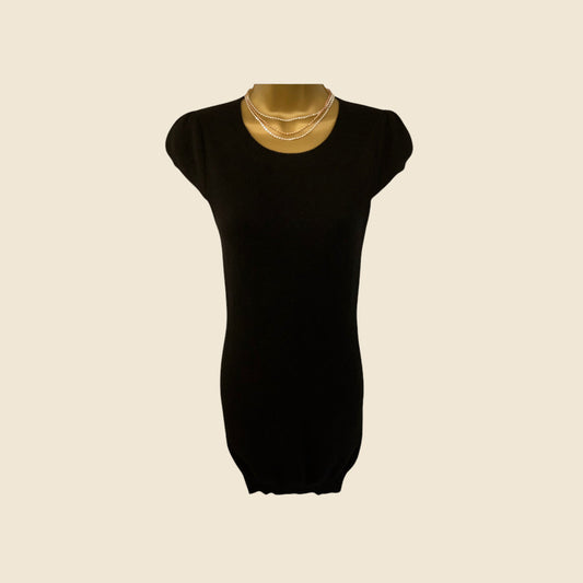 Black dress on a mannequin with a beige background