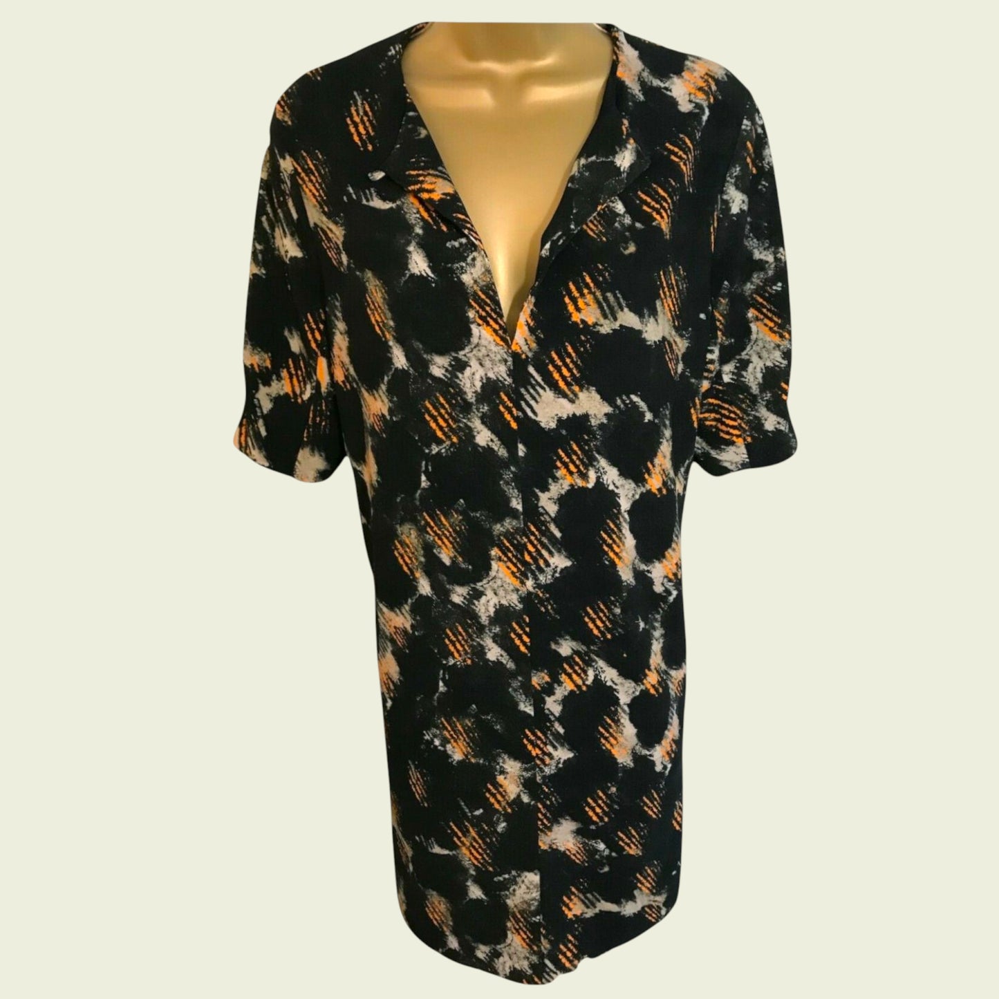 Black patterned dress on a mannequin against a white background