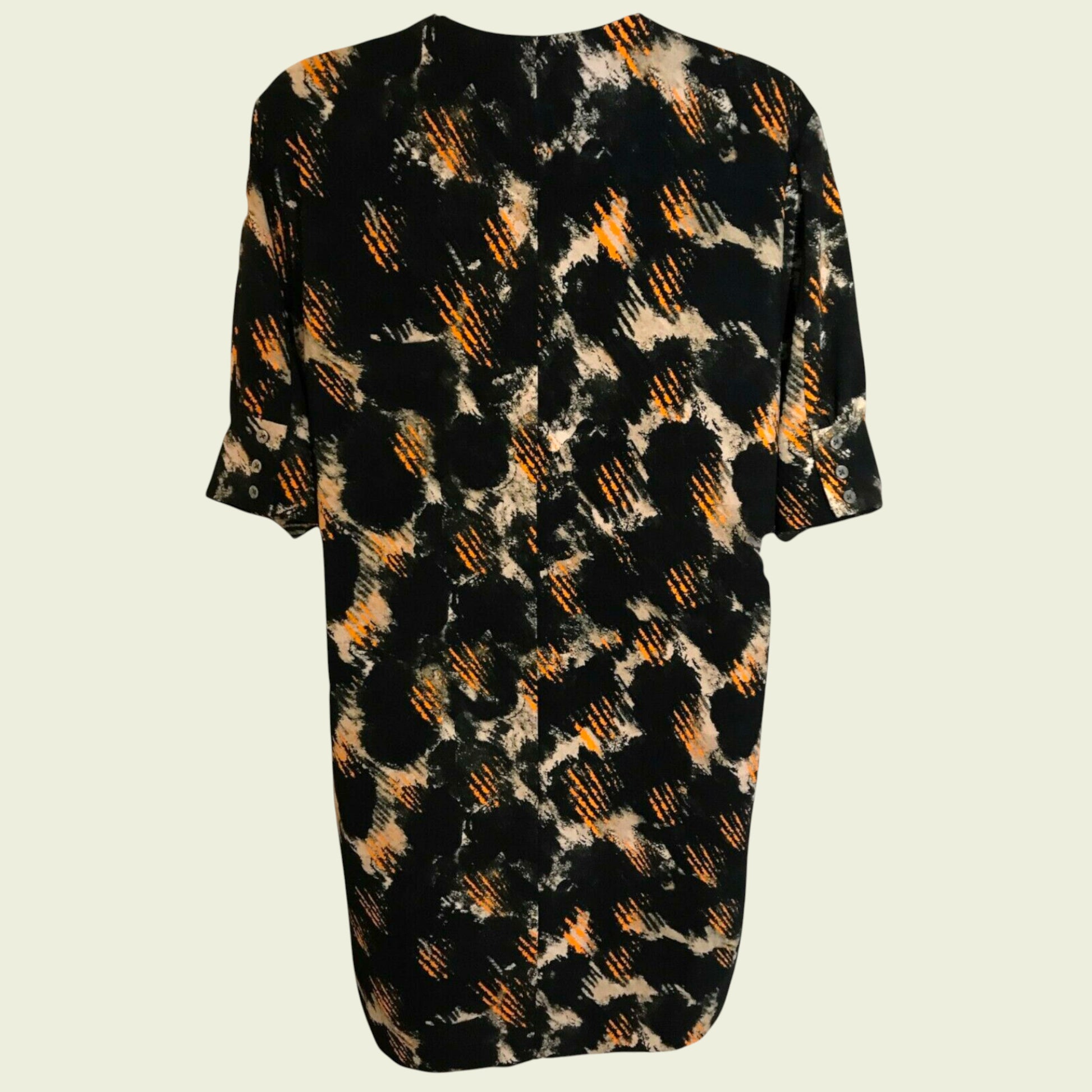 Black dress with abstract orange and beige pattern on a light gray background