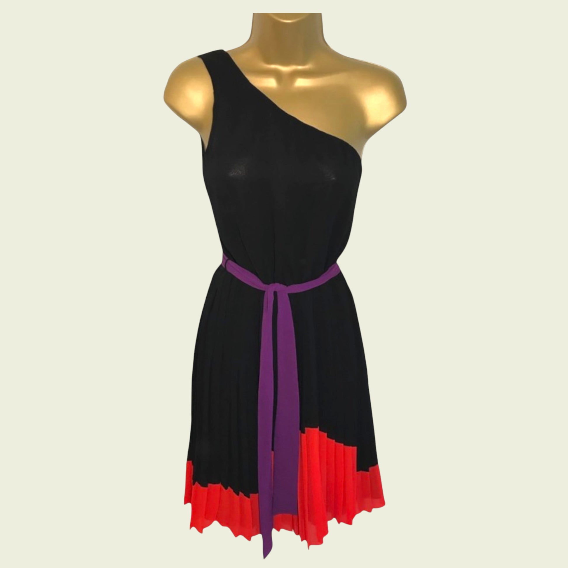 Black dress with purple belt and red bottom on a mannequin against a beige background