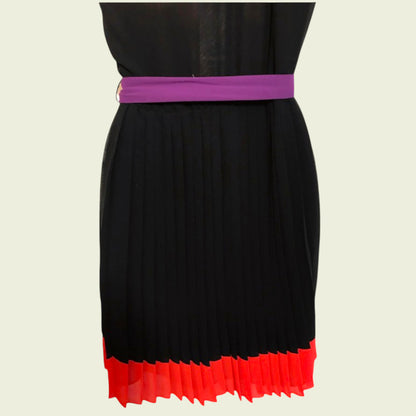 Black dress with a purple belt and red hem on a beige background