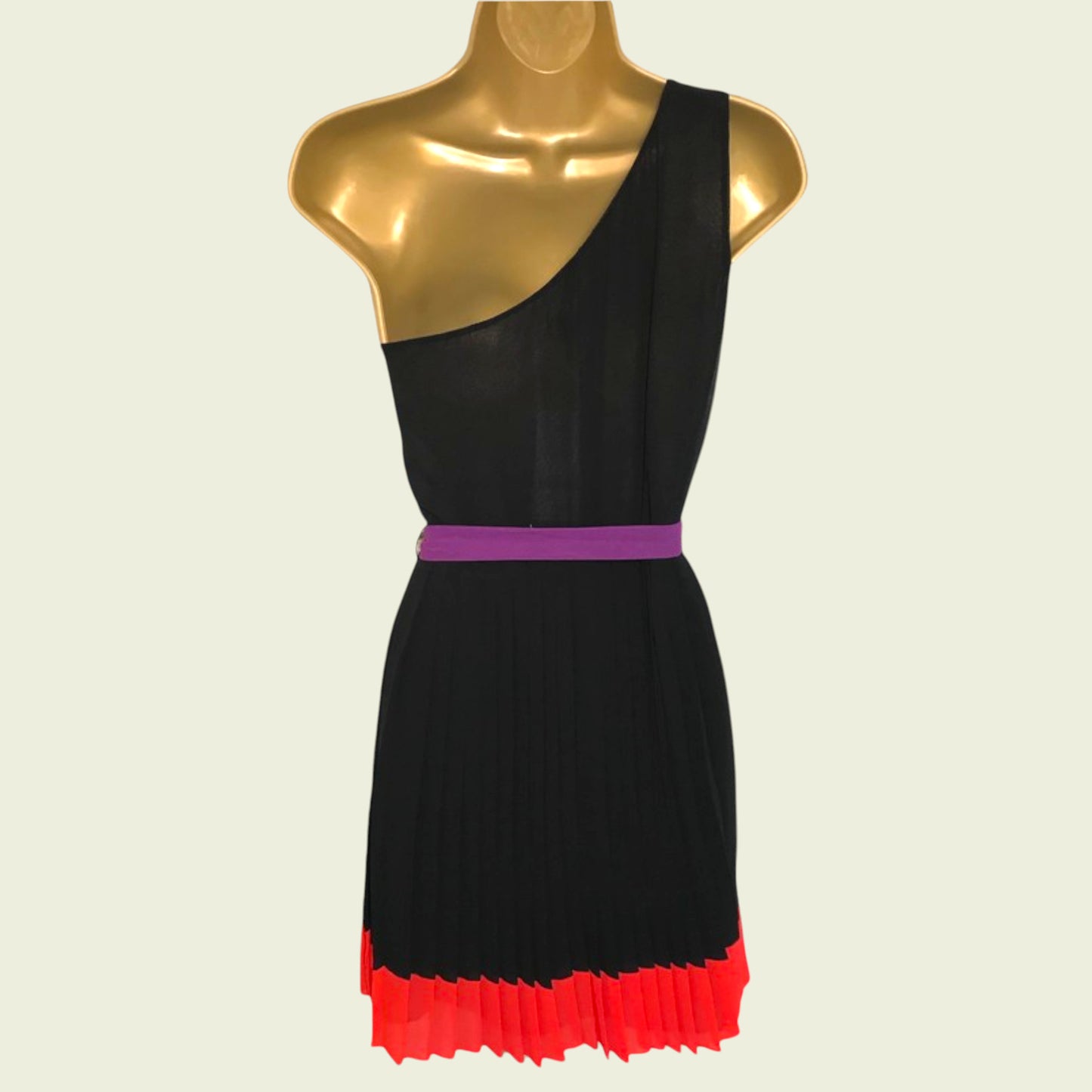 Black dress with a purple belt and red hem on a mannequin against a beige background