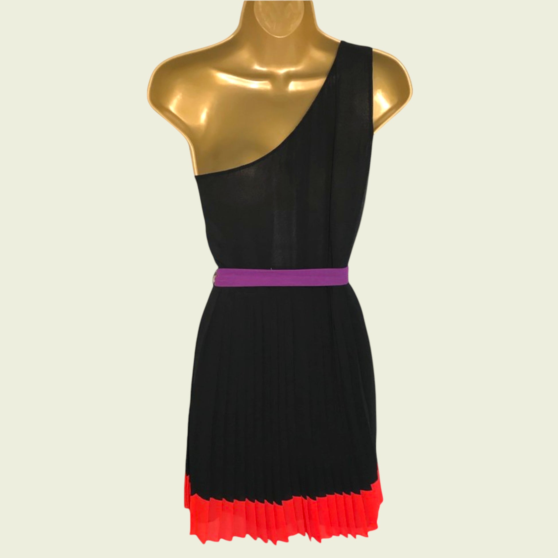Black dress with a purple belt and red hem on a mannequin against a beige background