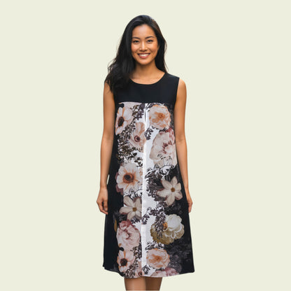 Woman wearing a black sleeveless dress with floral pattern on a beige background