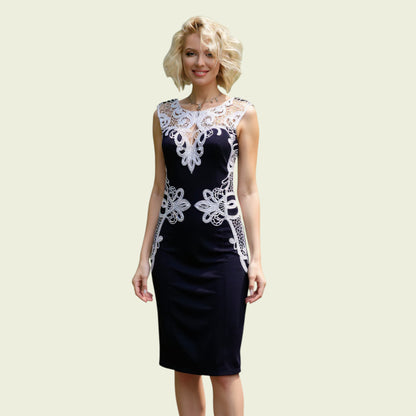Woman wearing a navy dress with white lace details on a beige background