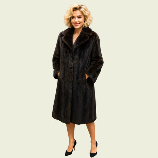 Woman wearing a long fur coat on a plain background