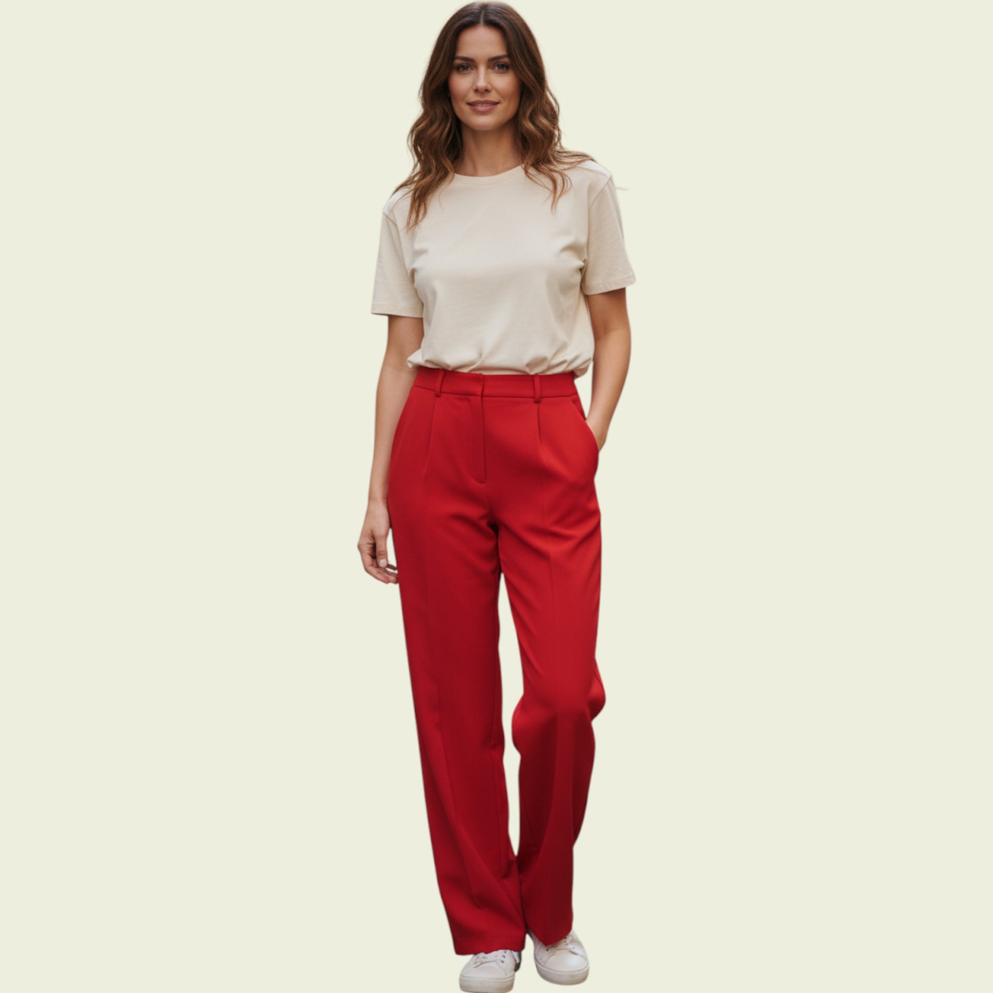 Woman wearing a beige top and red pants on a beige background