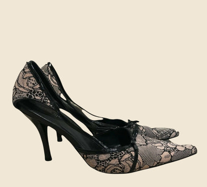 Black high-heeled shoes with snake print on a beige background