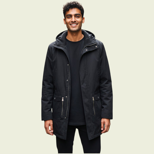 Man wearing a black coat on a beige background