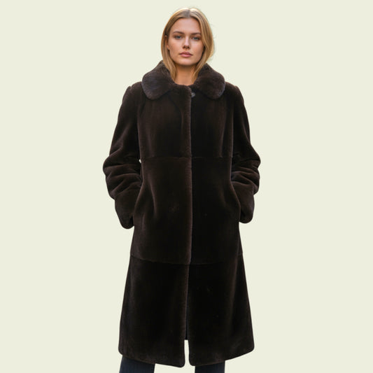 Woman wearing a brown coat on a beige background