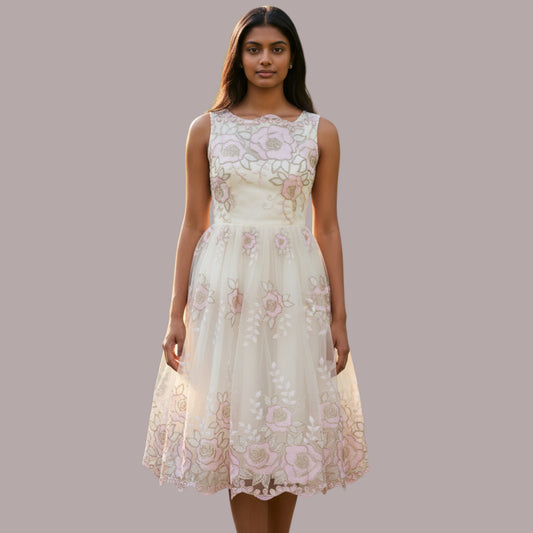 Woman wearing a floral lace dress against a plain background